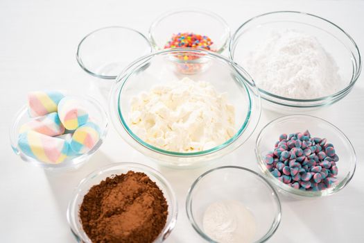 Measured ingredients in glass mixing bowls to make unicorn hot chocolate mix.