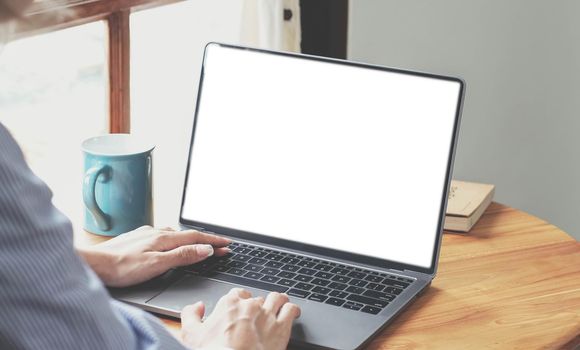 Close-up, Business woman using portable laptop computer at her desk. Laptop blank screen mockup.