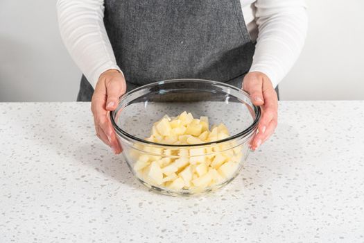 Mixing ingredients in a large glass mixing bowl to make potato salad.