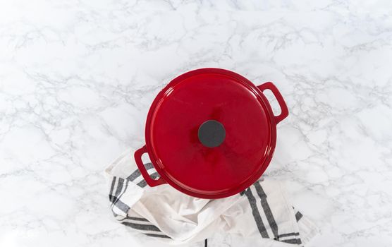 Flat lay. Cooking chicken noodle soup with kluski noodles in an enameled dutch oven.