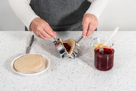 Filling empanada dough with cherry pie filling to make sweet cherry empanadas in the air fryer.