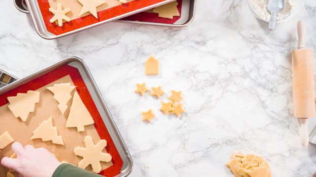 Flat lay. Step by step. Cutting out shapes with Christmas cookies cutter from sugar cookie dough.