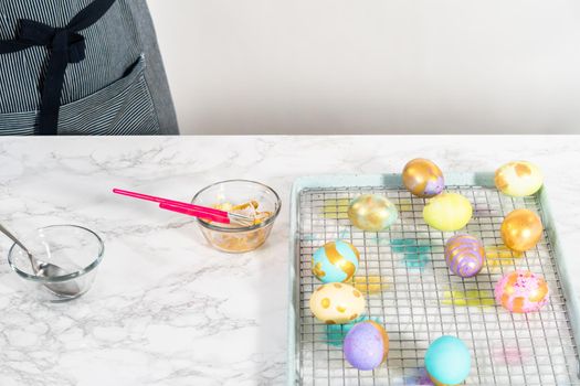 Easter egg coloring. Painting Easter eggs with gold luster.