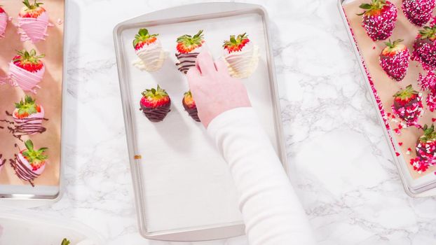 Flat lay. Step by step. Variety of chocolate dipped strawberries on a parchment paper.
