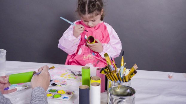 Kids papercraft. Painting empty toilet paper rolls with acrylic paint to create paper bugs.