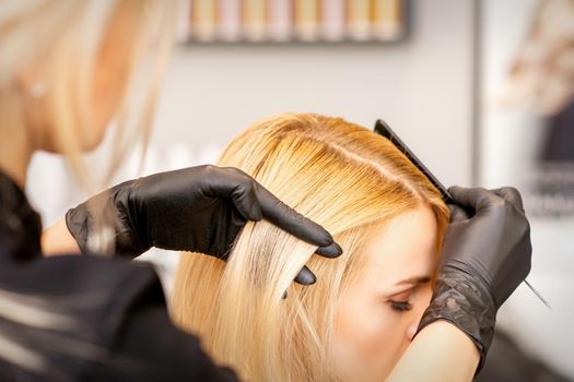 A hairdresser is combing female hairstyling in a hairdressing beauty salon
