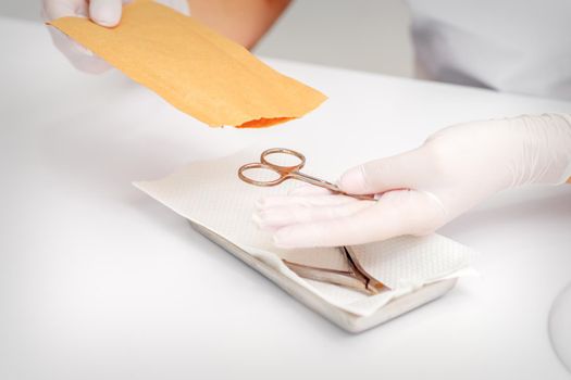 Master of manicure sterilizing manicure scissors. Disinfection of manicure tools