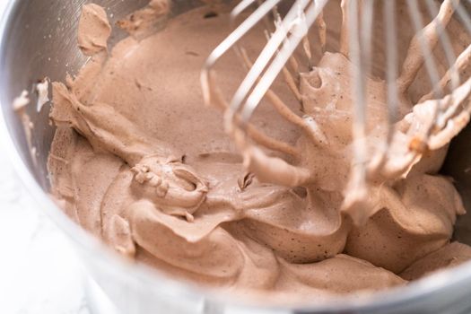 Mixing ingredients in a standing kitchen mixer to make homemade chocolate ice cream.