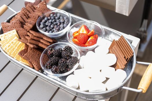 S'mores charcuterie board with fruits and star-shaped graham crakers. on the outdoor patio.