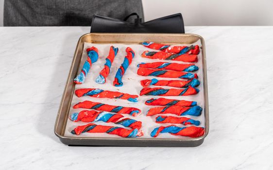 Rising patriotic cinnamon twists on the baking sheet lined with parchment paper.