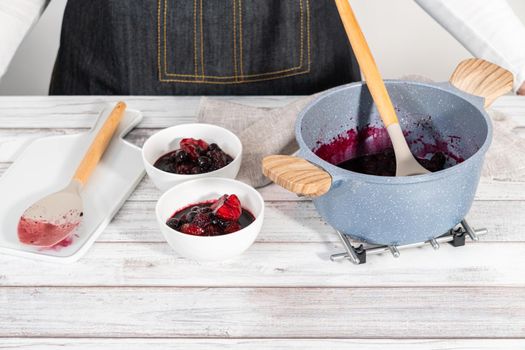 Preparing mixed berry compote from frozen berries in a nonstick cooking pot.