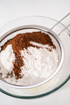 Sifting ingredients through hand sifter to make homemade hot chocolate mix.