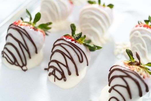 Organic strawberries dipped in chocolate drying on a parchment paper.