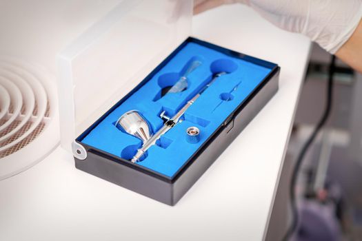 Close up of new clean airbrush tool in the blue box