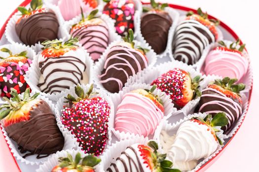 Variety of chocolate dipped strawberries in a heart-shaped box.