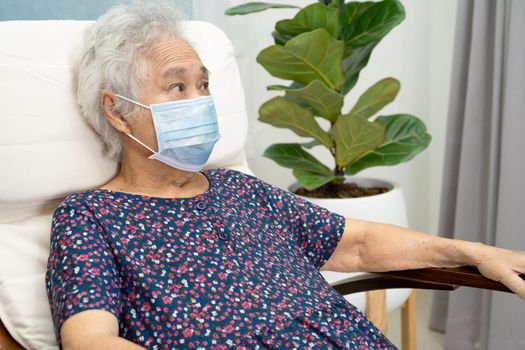 Asian elderly woman sitting and relaxing with happy in rocking chair at room in home.