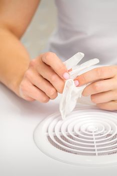 Beautician, doctor, or manicurist holds white latex protective gloves while preparing to wear them before providing services