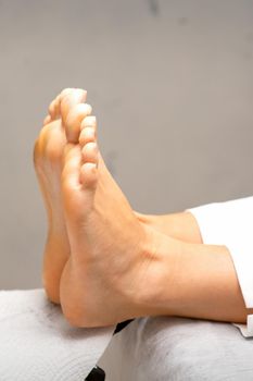 Beautiful feet with during pedicure lying on the couch in beauty salon close up