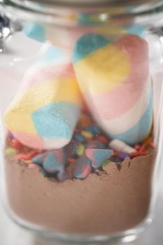 Making unicorn hot chocolate mix in drinking mason jar as a food gift.