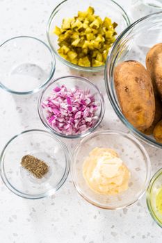 Measured ingredients in glass mixing bowls to make potato salad.