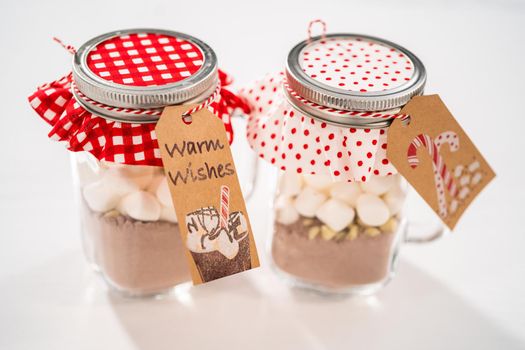 Making homemade hot chocolate mix in drinking mason jar for Christmas food gift.