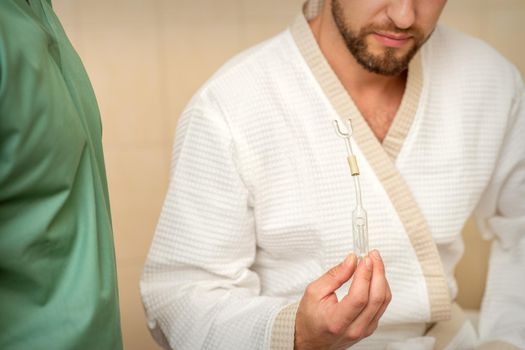 Young caucasian man receiving nasal inhalation Maholda with essential oil in the nose at a hospital