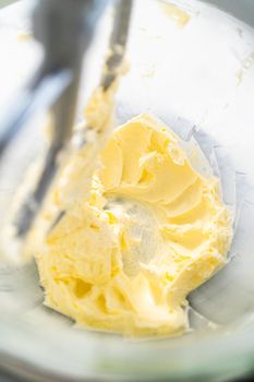 Mixing ingredients in kitchen electric mixer to make lemon buttercream frosting.