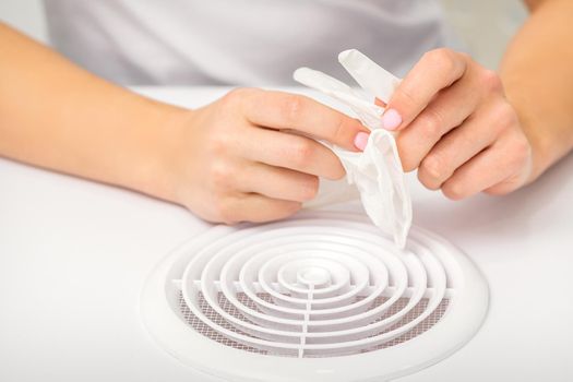 Beautician, doctor, or manicurist holds white latex protective gloves while preparing to wear them before providing services