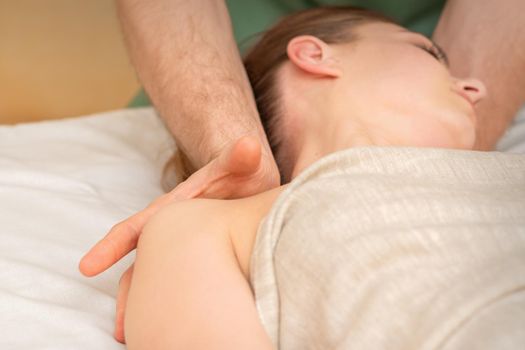 Young caucasian woman having a massage on the shoulder in spa salon