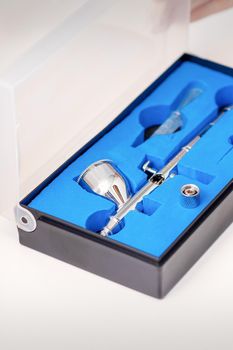 Close up of new clean airbrush tool in the blue box
