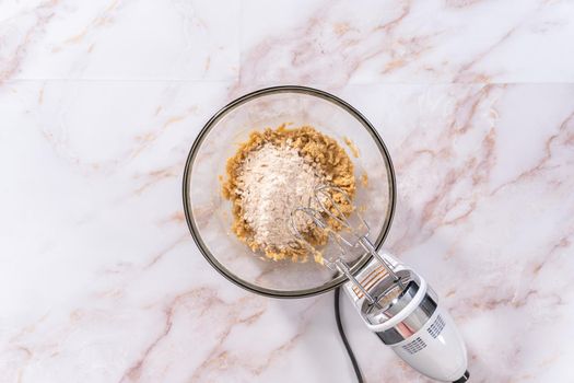 Flat lay. Mixing ingredients in a large glass mixing bowl to bake apple oatmeal cookies.