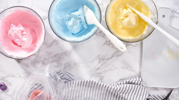 Step by step. Flat lay. Mixing food coloring into the meringue to bake unicorn meringue cookies.