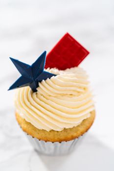 Lemon cupcakes with lemon buttercream frosting, and decorated with patriotic blue chocolate star and red mini chocolate.