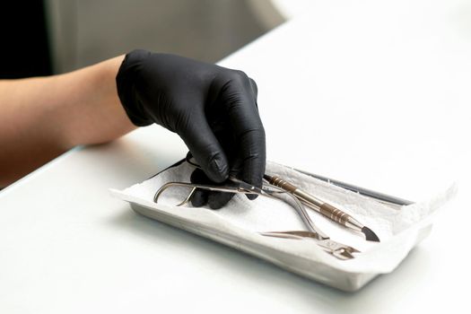 Professional manicure master prepares nail care tools on a white background with copy space
