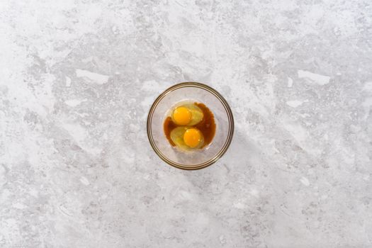 Mixing ingredients in a glass mixing bowl to prepare coconut banana pancakes.