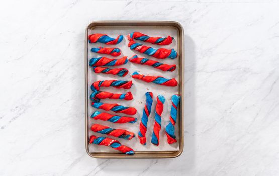 Flat lay. Rising patriotic cinnamon twists on the baking sheet lined with parchment paper.