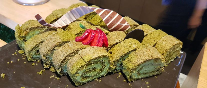 Sponge roll cake with strawberry and chocolate slice and pistachio, food photography concept in fancy restaurant