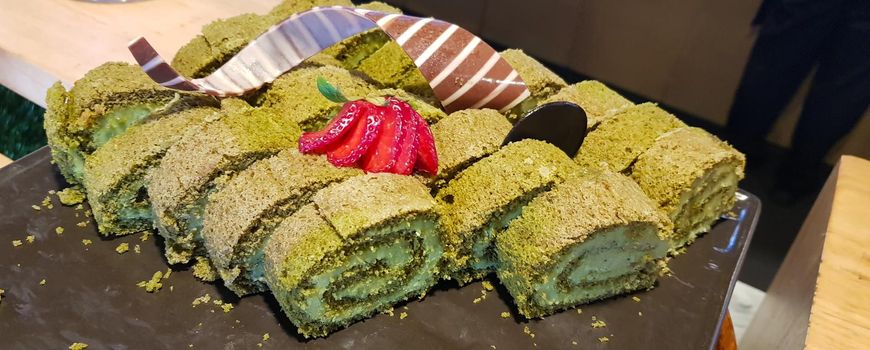 Sponge roll cake with strawberry and chocolate slice and pistachio, food photography concept in fancy restaurant