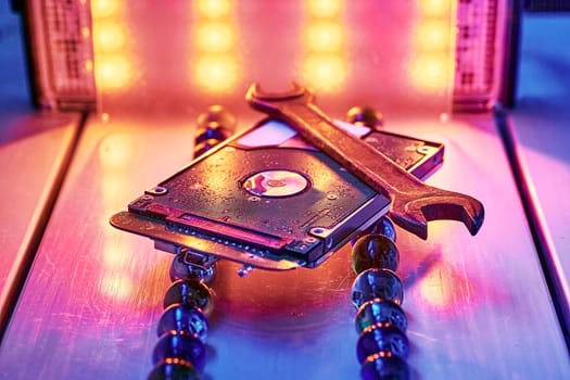 the concept of data, hardware, and information technology. The abstract image of hard disk and wrench drive on the technicians desk as a component.