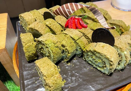 Sponge roll cake with strawberry and chocolate slice and pistachio, food photography concept in fancy restaurant