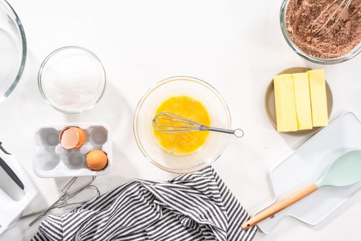 Flat lay. Mixing ingredients in a glass mixing bowl to bake chocolate cookies.