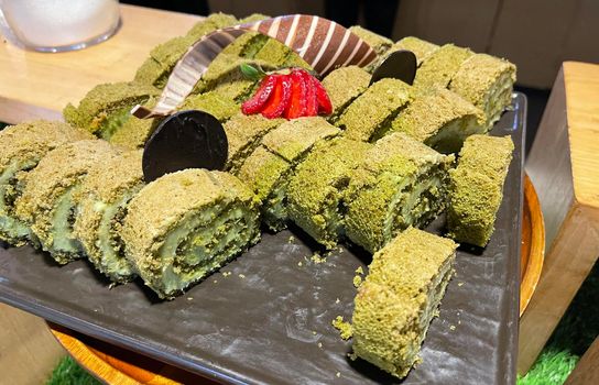 Sponge roll cake with strawberry and chocolate slice and pistachio, food photography concept in fancy restaurant