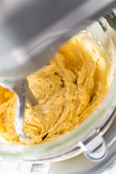 Mixing ingredients in kitchen mixer to bake mini Easter bread kulich.