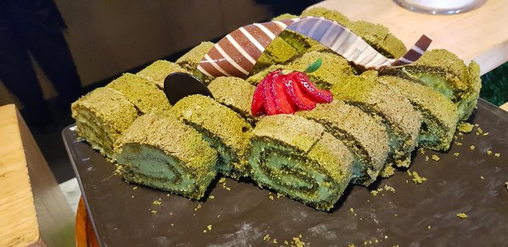 Sponge roll cake with strawberry and chocolate slice and pistachio, food photography concept in fancy restaurant