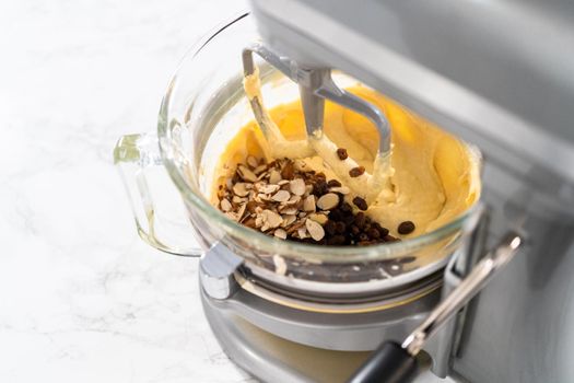 Mixing ingredients in kitchen mixer to bake mini Easter bread kulich.