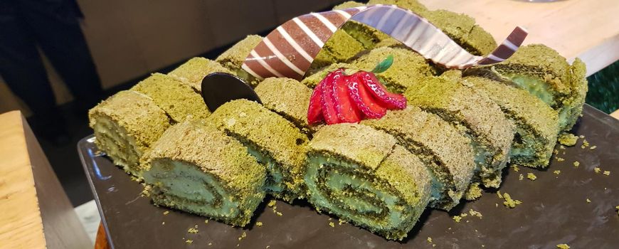 Sponge roll cake with strawberry and chocolate slice and pistachio, food photography concept in fancy restaurant