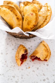 Freshly baked sweet cherry empanadas in the air fryer on the kitchen counter.