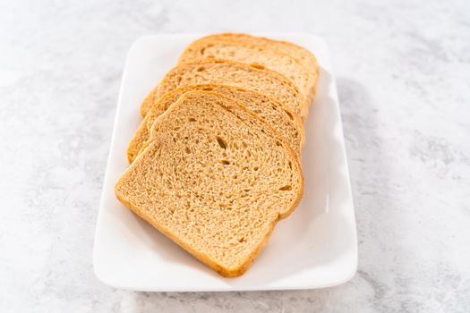 Stale bread on a white plate to make bread crumbs.