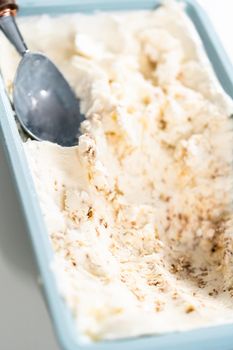 Preparing homemade coconut ice cream with roasted coconut flakes.