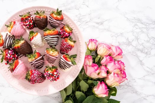 Flat lay. Variety of chocolate dipped strawberries on a pink cake stand.
